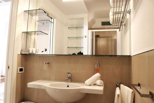 y baño con lavabo y espejo. en kaDevi piazza Bresca - pieno centro, parcheggio, bici, en San Remo