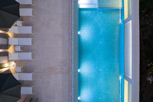 an overhead view of a swimming pool with an umbrella at Aurora apartments in Chania