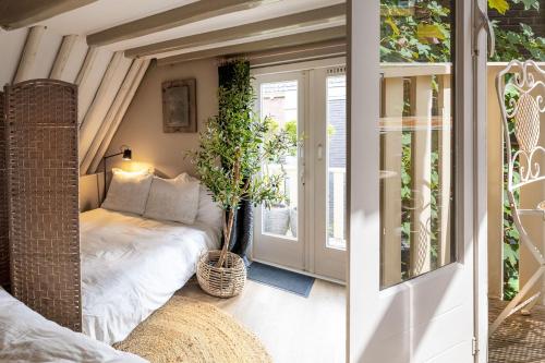 una piccola stanza con un letto e una finestra di Stadslogies City Penthouse a Leeuwarden