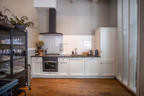 - une cuisine avec des placards blancs et une cuisinière dans l'établissement City House Grande Madame Agaath, à Leeuwarden