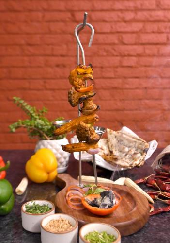 a table with a bunch of food on a hook at Bhanu The Fern Forest Resort & Spa, Jambughoda in Jambughoda