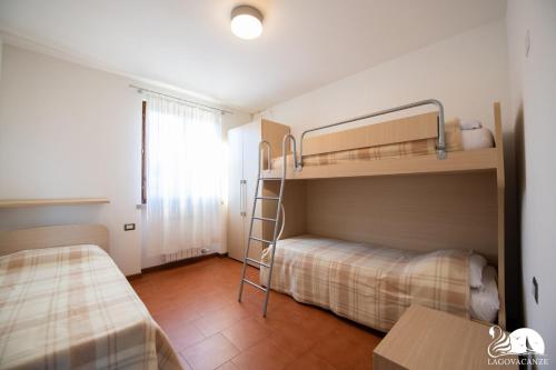 Kleines Zimmer mit 2 Etagenbetten und einem Tisch in der Unterkunft Paraìso del Sol in Polpenazze del Garda