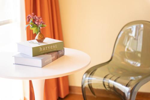 a table with a stack of books and a chair at 樹蘭蕉 箱根仙石原 - JYURANSHO Hakonesengokuhara in Hakone