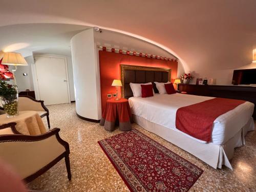 a hotel room with a large bed and a chair at Ruzzini Palace Hotel in Venice