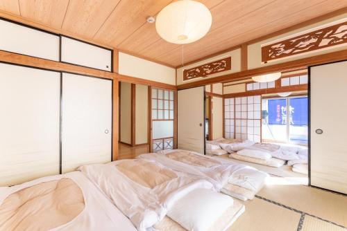 箱根樹蘭蕉 箱根仙石原 - JYURANSHO Hakonesengokuhara的一间设有四张床的窗户客房