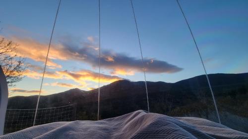 a reflection of a sunset in a building with a blanket at La Bulle d'Ardèche in La Chanal
