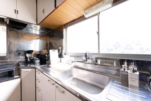 a kitchen with a sink and a window at 樹蘭蕉 箱根仙石原 - JYURANSHO Hakonesengokuhara in Hakone