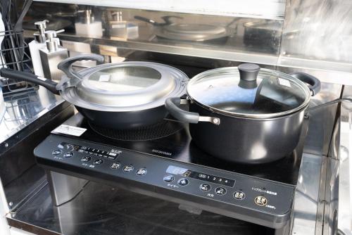 two pots and pans sitting on top of a stove at 樹蘭蕉 箱根仙石原 - JYURANSHO Hakonesengokuhara in Hakone