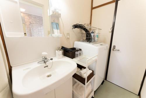 a bathroom with a white sink and a mirror at 樹蘭蕉 箱根仙石原 - JYURANSHO Hakonesengokuhara in Hakone
