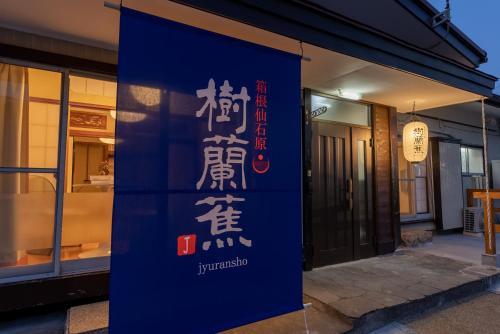a blue sign with chinese writing on a building at 樹蘭蕉 箱根仙石原 - JYURANSHO Hakonesengokuhara in Hakone