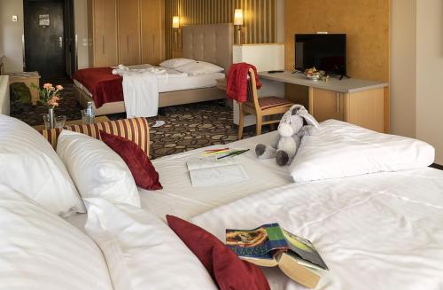 a hotel room with two beds with a stuffed animal on them at Berghotel Bastei in Lohmen