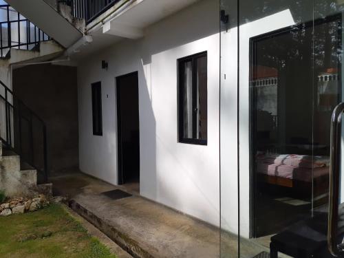 a house with a glass door with a bed in it at Siril Guesthouse Hostel in Nuwara Eliya