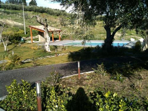 uma piscina com um pavilhão ao lado de uma estrada em Vecchia Dimora Resort em Centuripe