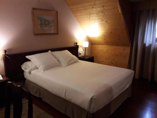 a hotel room with a bed and a lamp at Parador de Artíes in Arties