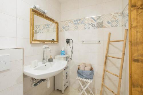 a white bathroom with a sink and a mirror at Apartmány Uprostřed zeleně in Lednice