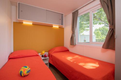 a bedroom with two beds and a soccer ball on the floor at San Francesco Camping Village in Desenzano del Garda