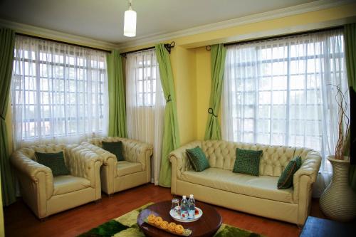 a living room with two couches and a table at Davis Court in Nyeri