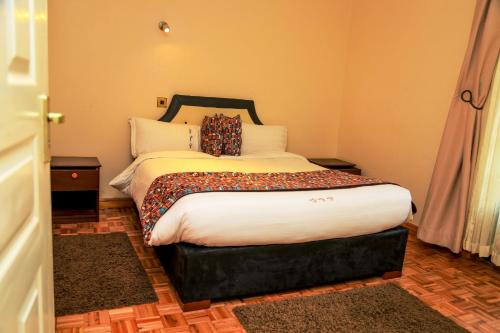 a bedroom with a large bed in a room at Davis Court in Nyeri