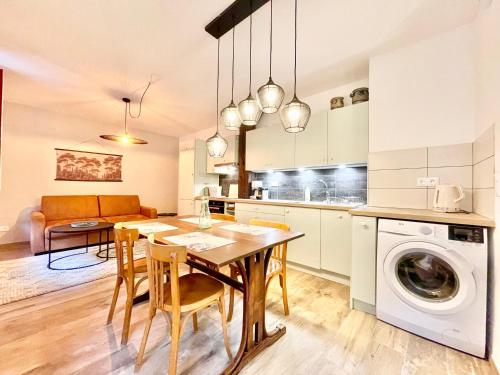 une cuisine et une salle à manger avec une table et un lave-linge dans l'établissement Colmar - Le Nichoir - Centre historique - Parking Gratuit - Box vélo & poussette, à Colmar