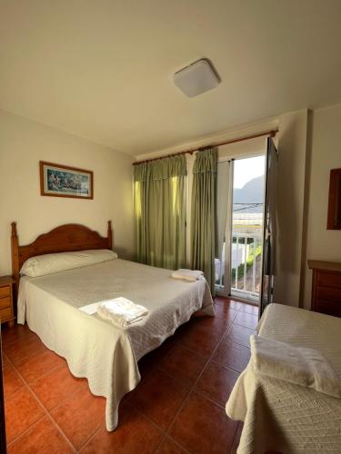 sypialnia z 2 łóżkami i dużym oknem w obiekcie Hotel Los Cascajos w mieście San Nicolás