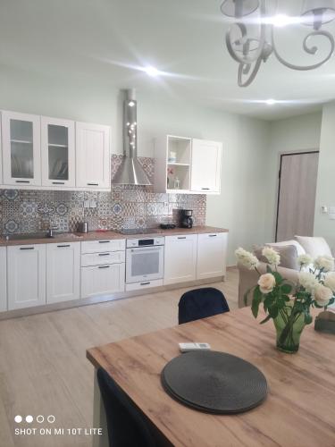 a kitchen with white cabinets and a wooden table at Diacopto Country Houses in Diakopto