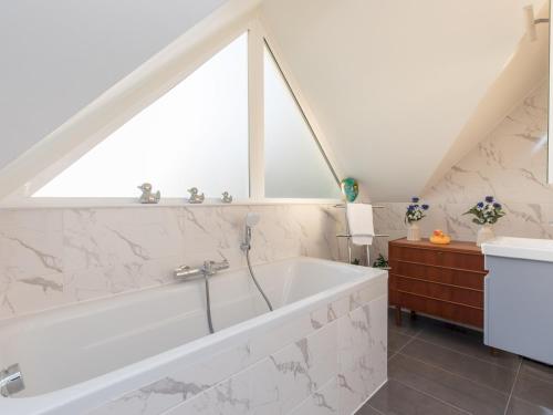 a bathroom with a white tub and a window at Pass the Keys Stunning 7 Sleeper Penthouse on Windsor Riverside in Windsor