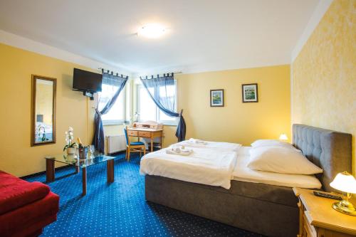 a hotel room with a bed and a red couch at Hotel Altstadt in Effeld