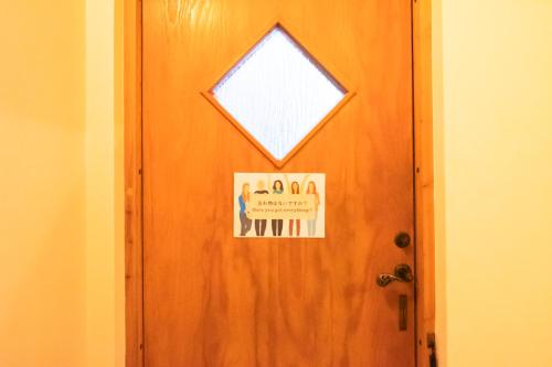 a door with a sign on it with a window at Woodhouse Yasunaya in Lake Toya