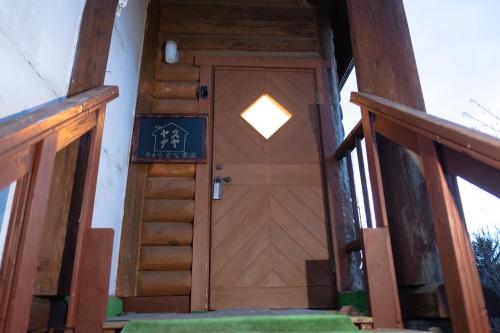 a wooden door with a light on top of it at Woodhouse Yasunaya in Lake Toya