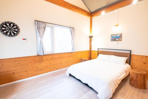 a bedroom with a bed and a window at Woodhouse Yasunaya in Lake Toya