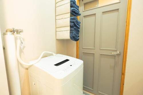 a laundry room with a washer and dryer next to a door at Woodhouse Yasunaya in Lake Toya