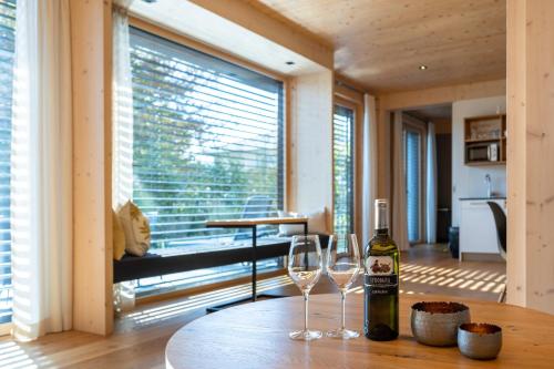 a bottle of wine and two wine glasses on a table at Atelier Ronacher in Annenheim