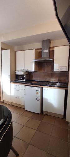 a kitchen with white cabinets and a black counter top at Apartamentos Boabdil in Sierra Nevada