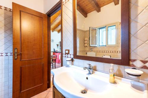 y baño con lavabo y espejo. en Villa Gabri en Carlentini