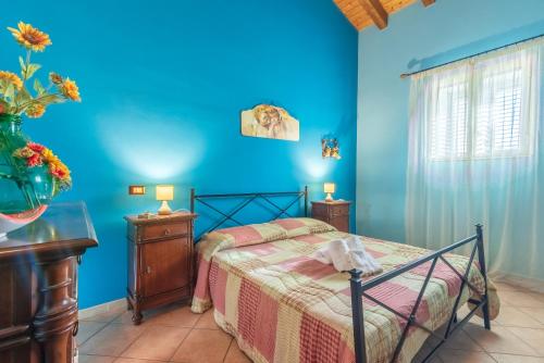 a bedroom with a bed and a blue wall at Villa Gabri in Carlentini