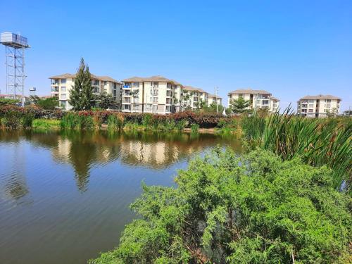 a body of water with apartment buildings in the background at Cozy Nest-2 Bedroomed Apartment WiFi ,Netflix close to JKIA in Syokimau