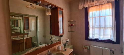 uma casa de banho com um lavatório e um espelho em Las Parientucas em Novales