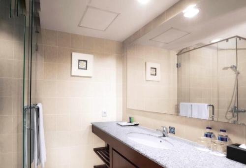 łazienka z umywalką i dużym lustrem w obiekcie Ancol Marina Residence w Dżakarcie