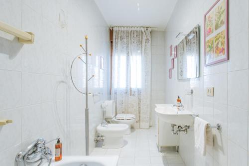 a white bathroom with a toilet and a sink at Yourbanflat Sweet Home in Padova