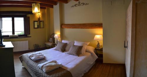 a bedroom with a bed with white sheets and pillows at Alba D'Esteve. Casa Rural in Espot