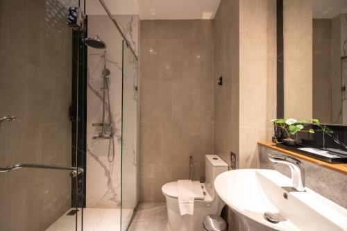 a bathroom with a shower and a toilet and a sink at SHAN Villas Sukhumvit in Bangkok