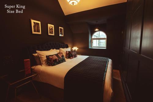a bedroom with a large bed in a dark room at The Rockefeller Apartments in Bowness-on-Windermere