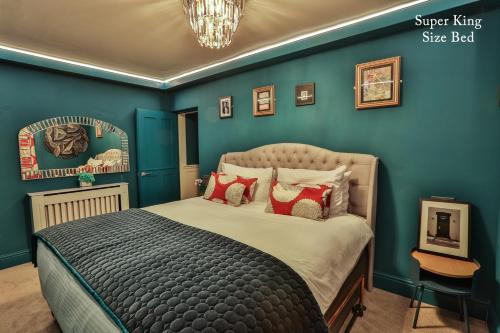 a bedroom with blue walls and a bed with red pillows at The Rockefeller Apartments in Bowness-on-Windermere