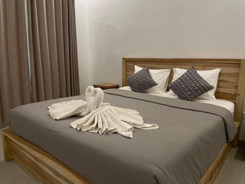 a bedroom with two beds with a towel animal on it at Hello Penida House in Nusa Penida