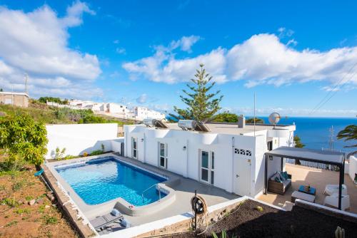 Tabaiba的住宿－Villa Verode - Private Heated Saltwater Pool，白色的房子,设有一个游泳池和大海