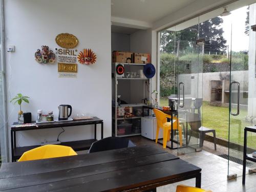 a dining room with a table and yellow chairs at Siril Guesthouse Hostel in Nuwara Eliya
