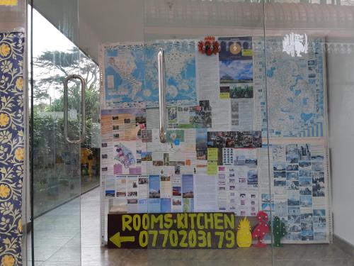 a glass door with a wall covered in papers at Siril Guesthouse Hostel in Nuwara Eliya