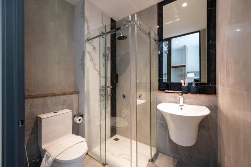 a bathroom with a shower and a toilet and a sink at SHAN Villas Sukhumvit in Bangkok
