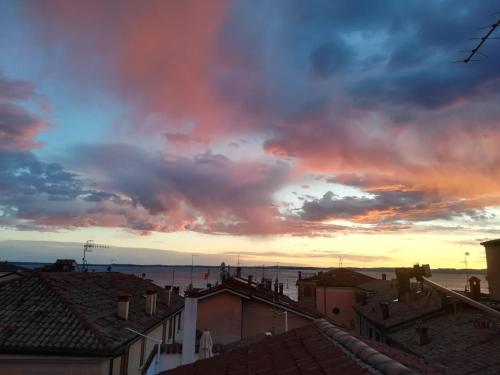 a sunset over the roofs of houses in a city at Bardoliners in Bardolino