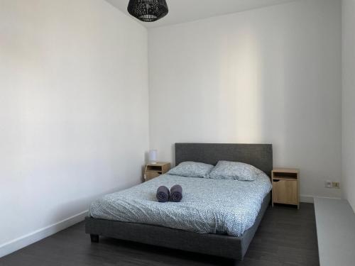 - une chambre avec un lit avec deux chaussures dans l'établissement Le Sarcoui - Appartement tout confort proche de la Gare, à Clermont-Ferrand